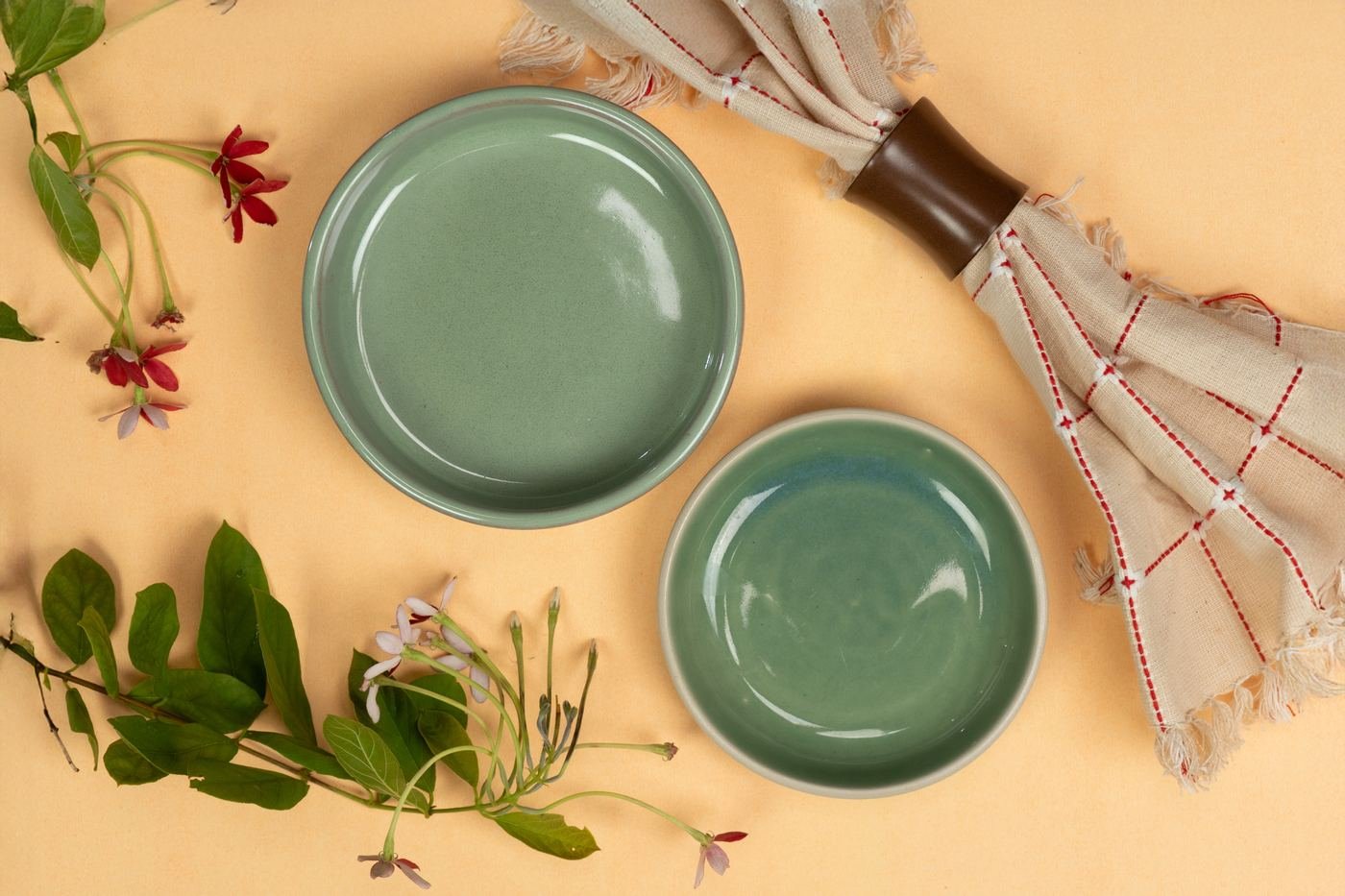Two sage green bowls with flowers and a woven napkin